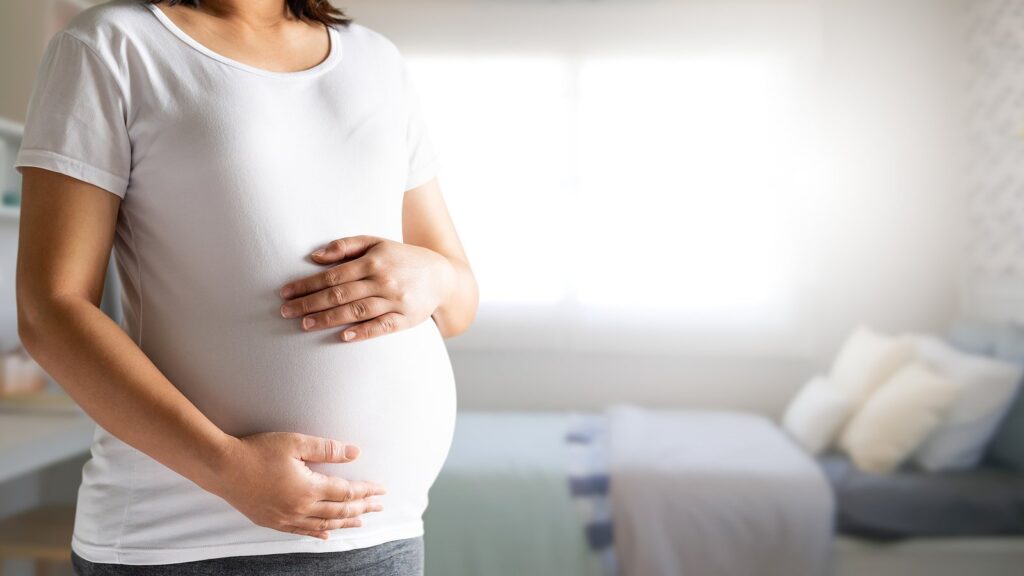 expecting mother holding baby in pregnant belly