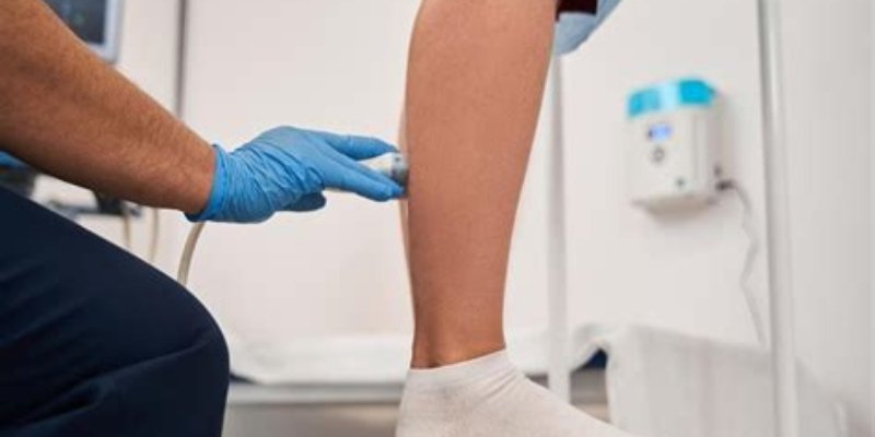 Vein specialist performing a diagnostic ultrasound examination on a patient’s leg